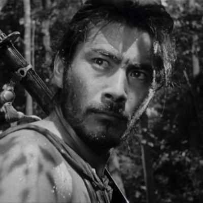 Film still from Rashomon, black and white image of man in nature.