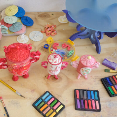 Artist Studio desk full of clay, colours and artwork